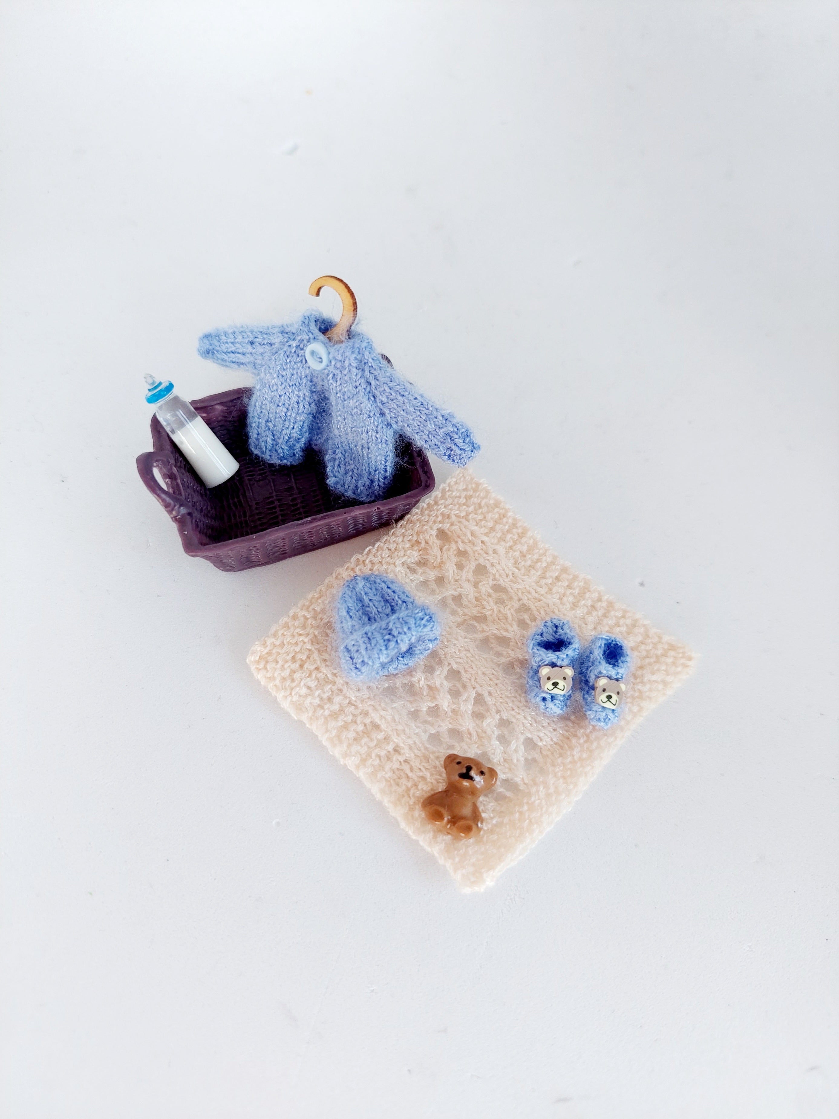 Handmade miniature baby basket with knitted clothes in blue – 1:12 scale dollhouse nursery set