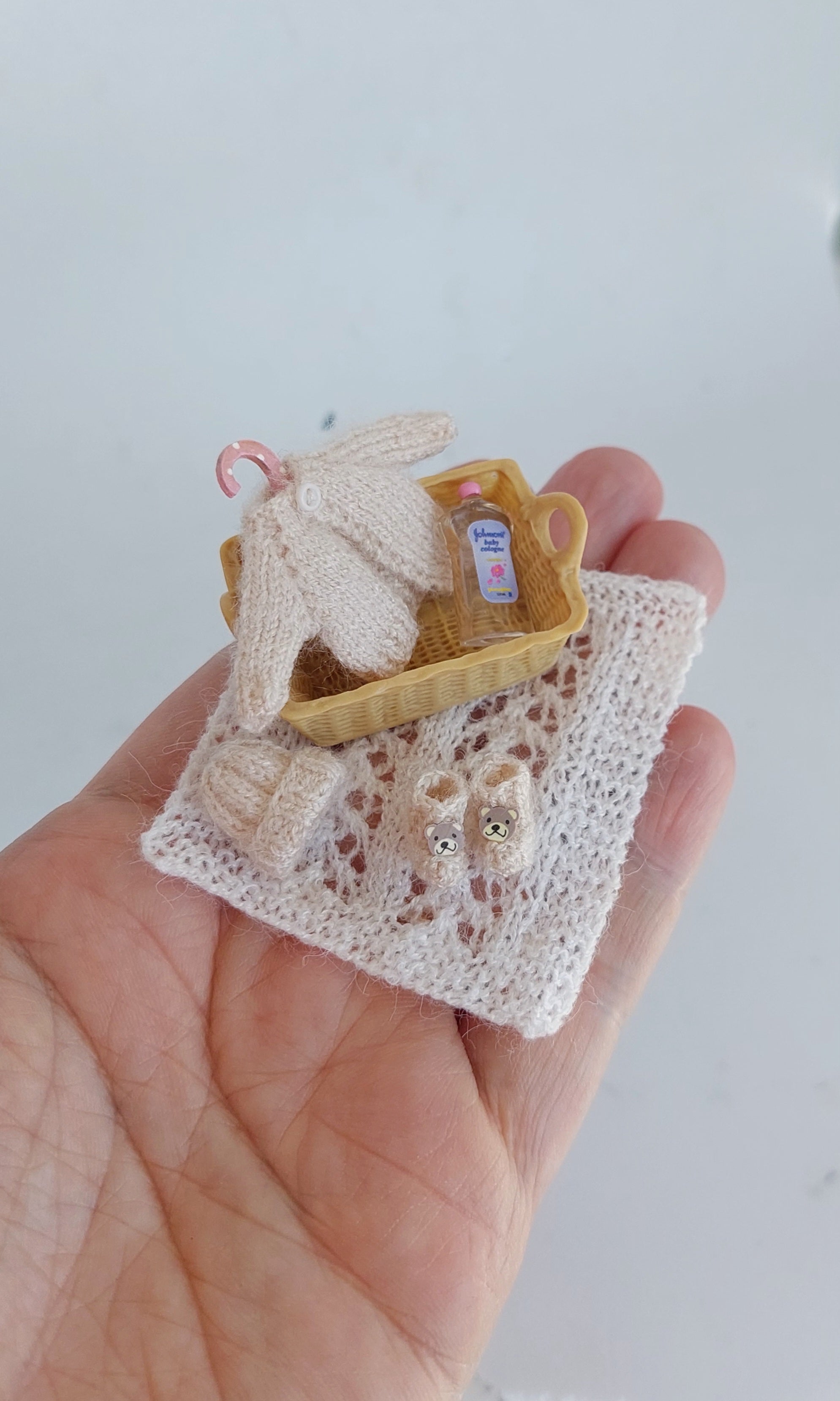 Handmade miniature baby basket with knitted clothes in beige – 1:12 scale dollhouse nursery set