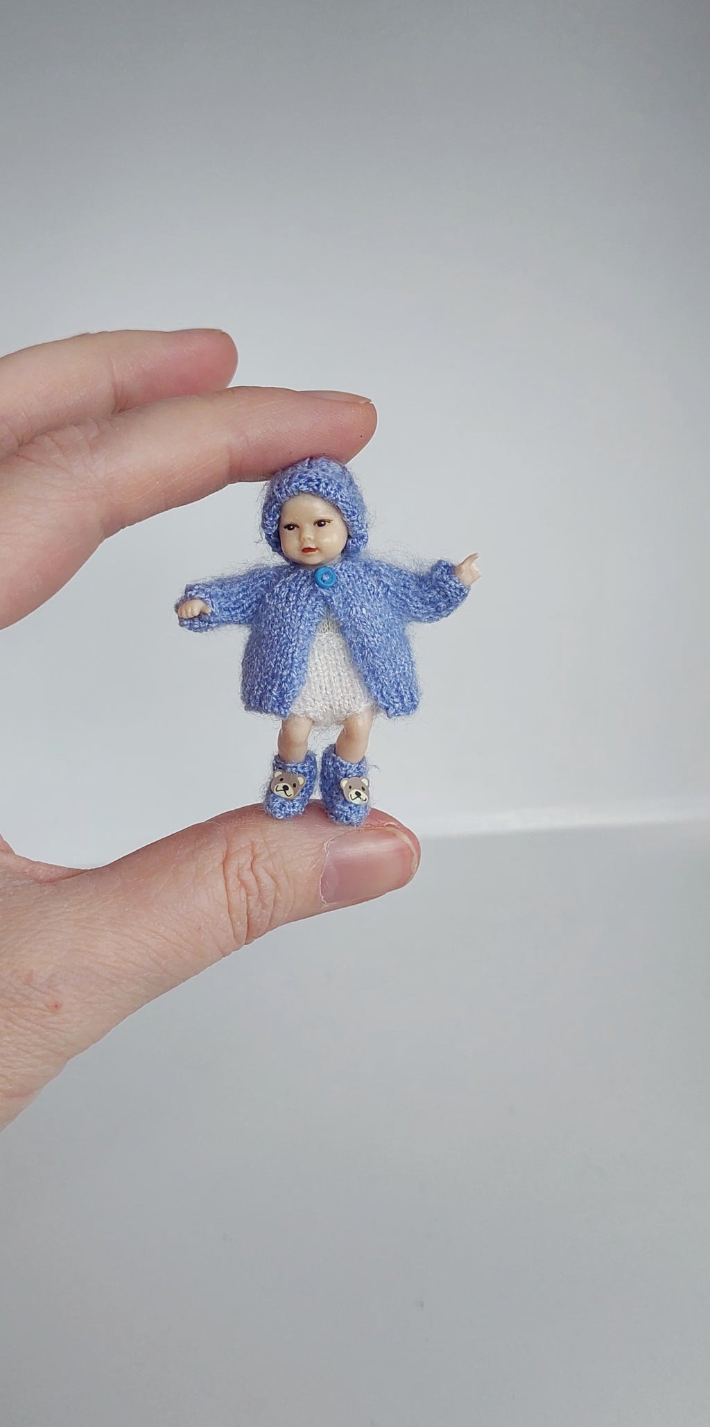 Handknitted miniature baby hat on 5 cm tall baby doll– real photo 1:12 scale dollhouse accessory
