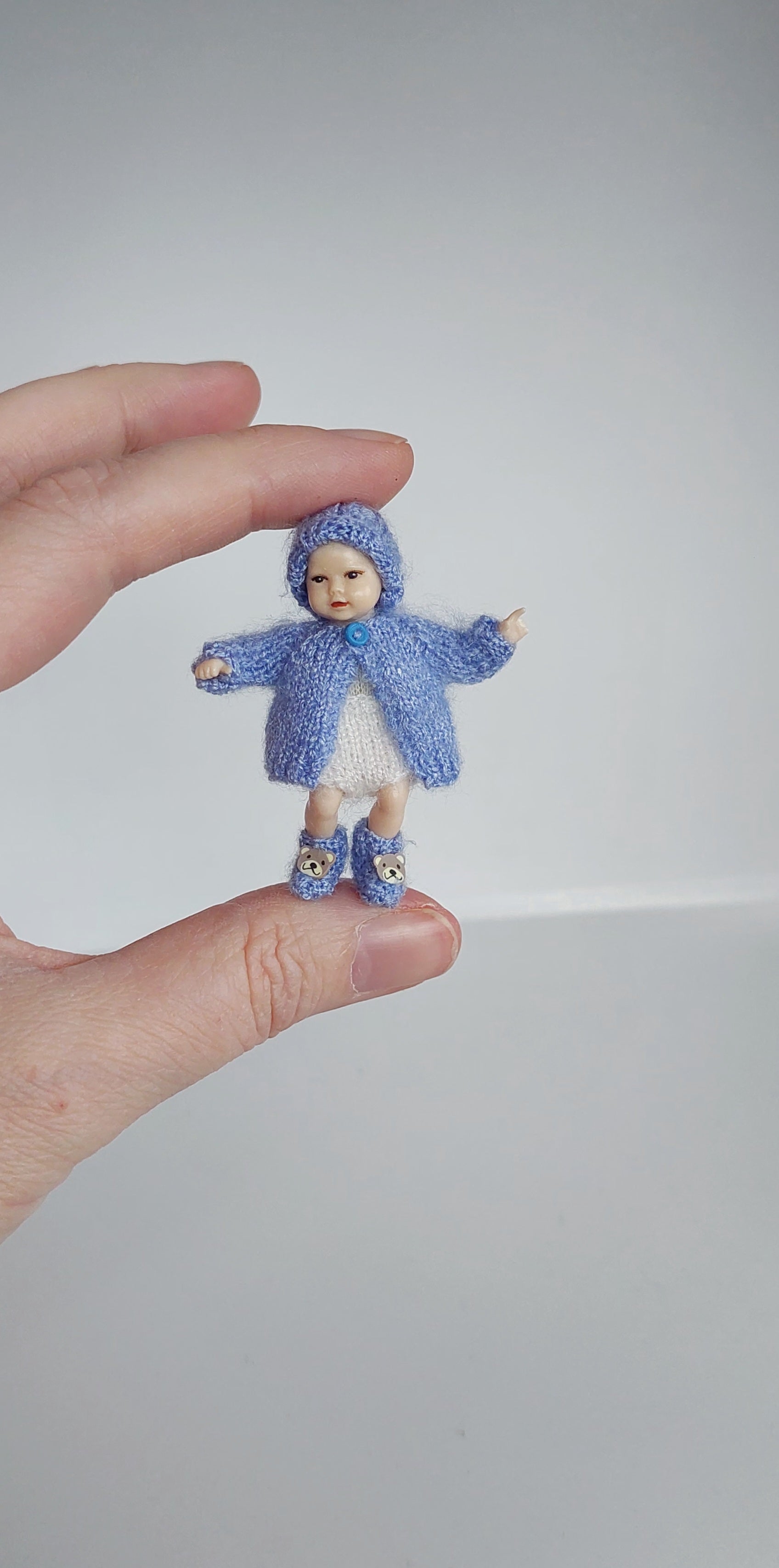 Handknitted miniature baby hat on 5 cm tall baby doll– real photo 1:12 scale dollhouse accessory