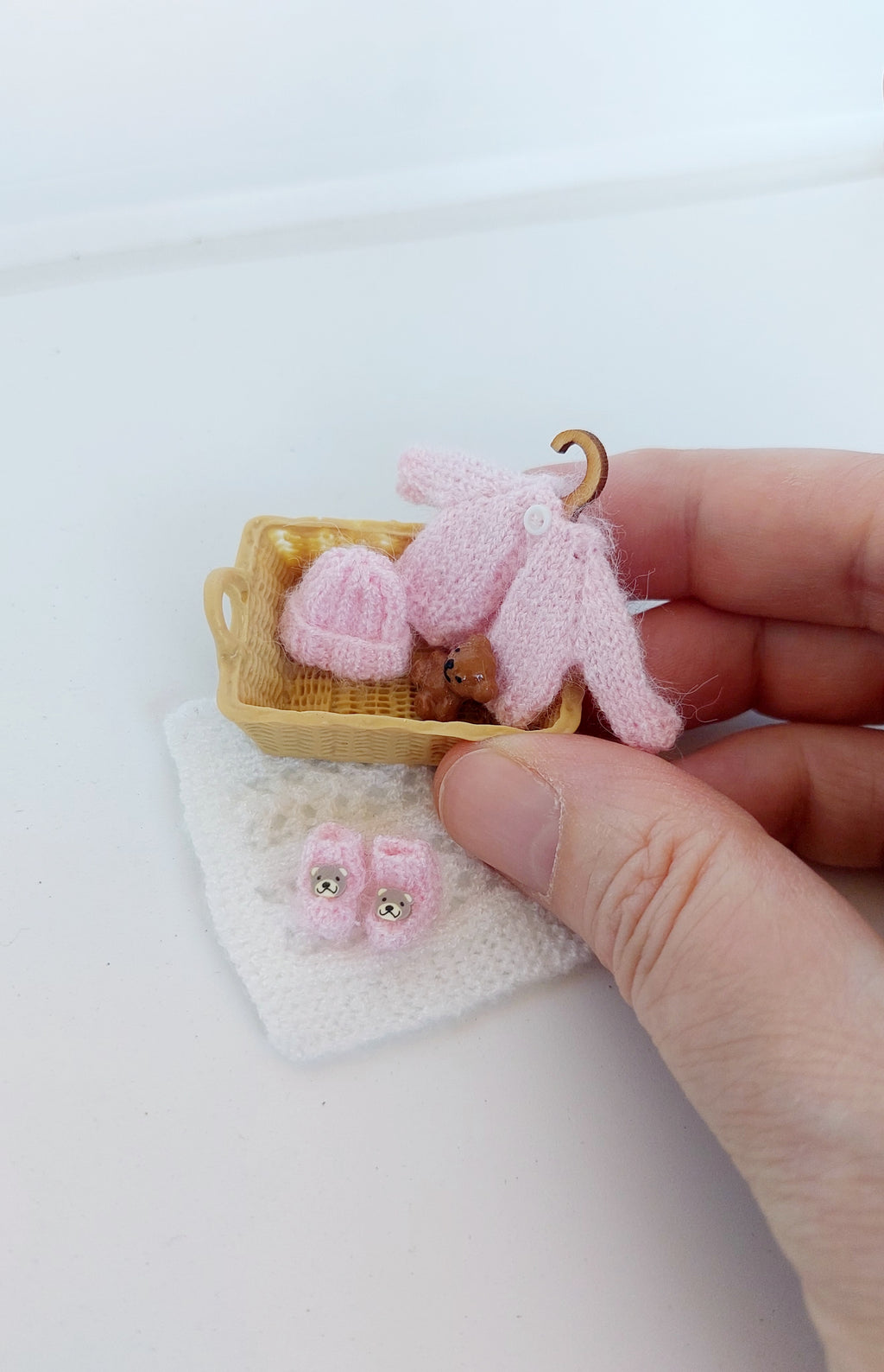 Handmade miniature baby basket with knitted clothes in pink – 1:12 scale dollhouse nursery set